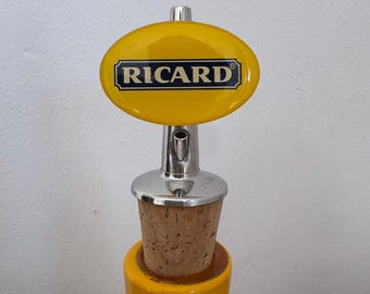 Un originale tappo per bottiglia Ricard giallo, iconico accessorio da bar francese.
