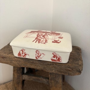 May include: A set of three ceramic mugs with a speckled, cream-colored glaze. Each mug features a different hand-painted design: a blue and green leaf, a yellow flower, and a red berry. The mugs have a simple, modern design.