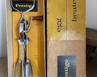 Batidora de huevos manual Prestige original, de acero inoxidable, estilo retro vintage, con mangos de madera de teca, en su caja original.