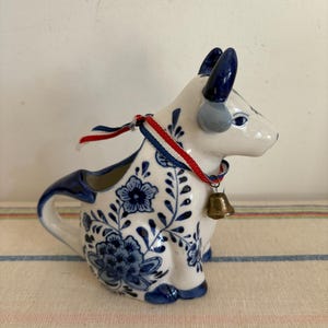 An original Delft blue and white  blue cow milk jug creamer  with neck bell