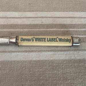 A vintage Dewars  White Label whisky advertising pencil within a case
