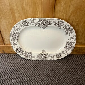May include: A white oval serving platter with a gray floral design around the edge.