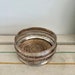 A well used antique  decorative  silver plated wine or champagne table coaster with wooden base