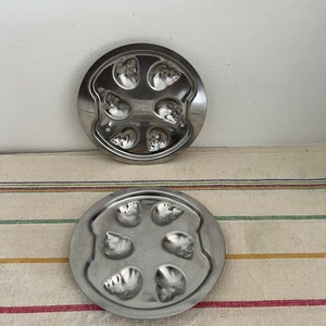 A traditional French vintage pair of round stainless steel escargot snail dishes