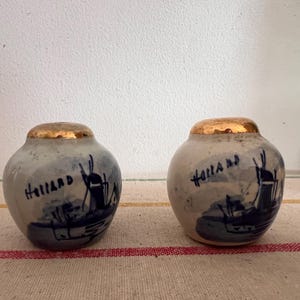 A pair of  cute size antique Delft Blue  Dutch Holland china hand painted blue and white shakers with gold tops