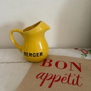 A cute, versatile yellow  ceramic  French promotional Berger pastis  water  carafe typical of the bistro cafe bar