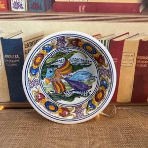 Un exclusivo cuenco de terracota esmaltada con decoración de peces pintado a mano, firmado por Skuro en colores verde, azul y amarillo.