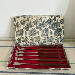 A vintage boxed 6 piece  set of stainless steel fondue forks with teak wooden handles