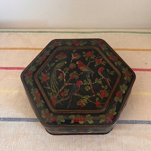 A rare vintage Tin Box- Black French hexagonal Tin Box  decorated with red and green parrots, tropical birds in a cherry tree
