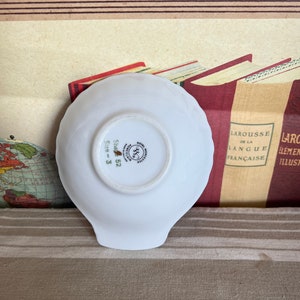 May include: White porcelain dish with a scalloped edge. The bottom of the dish has a gold and green logo that reads "Worcester Royal Porcelain" and "Size 3 Shape 52".