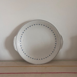 May include: White ceramic serving platter with two handles and a blue and white geometric pattern around the edge.