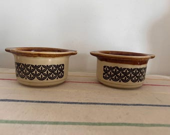 May include: Two brown and white ceramic bowls with a black geometric pattern. The bowls are slightly different sizes.