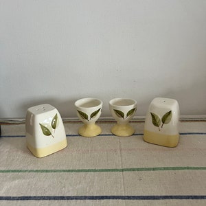 Ein hübsches handbemaltes Paar Eierbecher mit Blattdesign und passenden Salz- und Pfefferstreuern