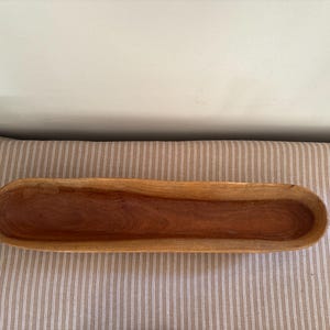 A large long wooden hand carved  canoe shaped baguette bread bowl
