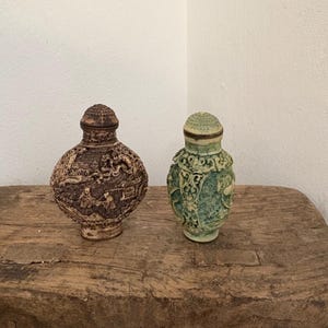 Puede incluir: Una taza de cerámica blanca con asa negra y el texto "But First, Coffee" en negrita negra. La taza está sobre un fondo borroso, sugiriendo un ambiente acogedor. La taza mide aproximadamente 10 cm de altura.