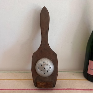 An antique wood and metal juicer in need of refurbishment