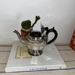 A vintage Viners of Sheffield  EPNS 6 cup capacity  pedestal teapot  with a hinged   lid and black Bakelite knob and handle