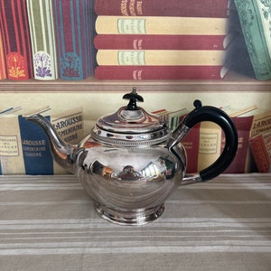 An  antique Victorian  EPBM silver plated  teapot with a bakelite handle and finial and  hinged lid
