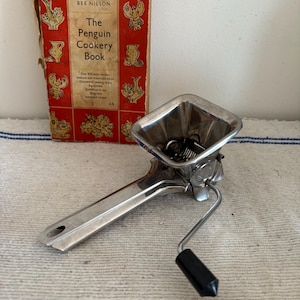 An original French retro stainless steel mint, parsley herb mincer masher mill with a black plastic handle