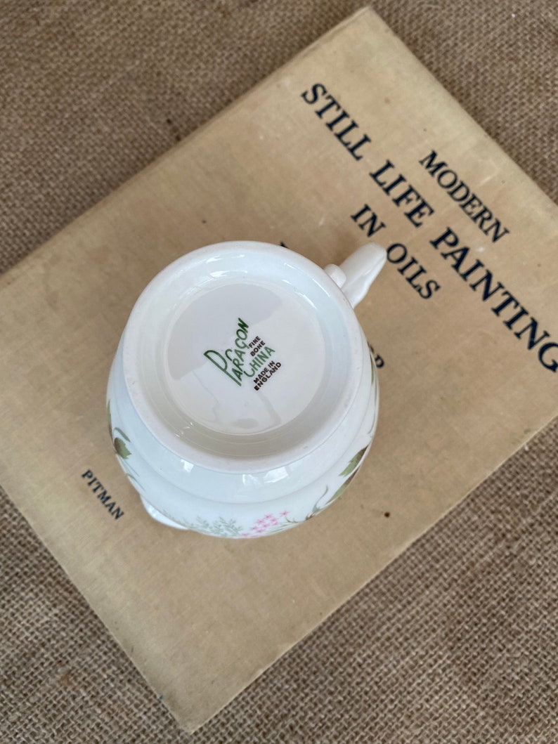 A Paragon fine bone china jug with a green and pink pattern and a gold rim around the top and base