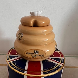 En söt handdekorerad karamellbrun keramisk honungsmielkruka med dekor av honungsbi och utstansad för Twizzler.