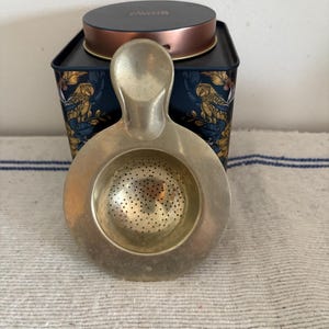 A well used antique 4&quot; diameter  German or Polish  loose tea strainer, infuser with makers stamp on front