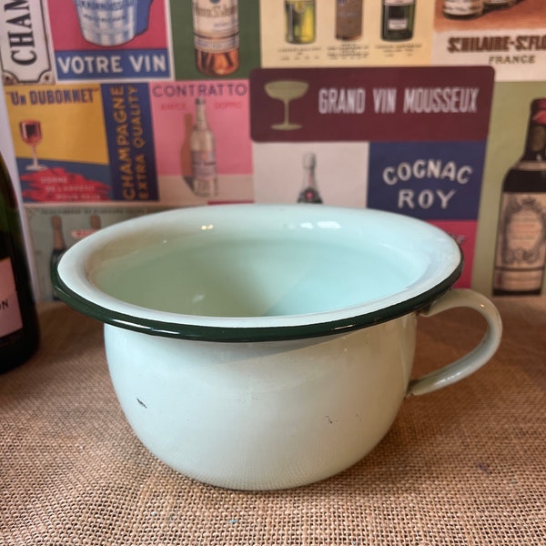 An original French vintage pale green enamel potty with bottle green rim