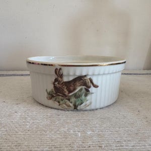 An original medium sized  Apilco white porcelain oven  proof souffle  dish with a game theme decor