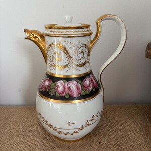 Caffettiera francese antica, alta 21,5 cm, in porcellana neoclassica del periodo Impero, con decorazioni floreali e dorate e beccuccio a forma di testa di animale.