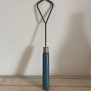 An original vintage retro push down beater hand whisk with a blue wooden handle