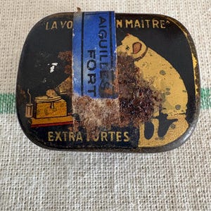 Uma caixa de metal com agulhas para telefone de gramática francesa vintage original da década de 1930 com tampa de lata (com agulhas)