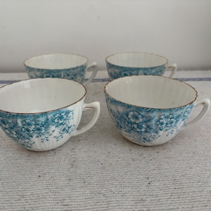 A set of four circa 1900s beautiful bone china  fluted tea cups with a lovely turquoise flower pattern and gold detailing