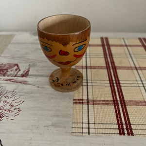 A collectible early 20th century retro Norwegian Drammen varnished  wooden painted egg cup with a face design