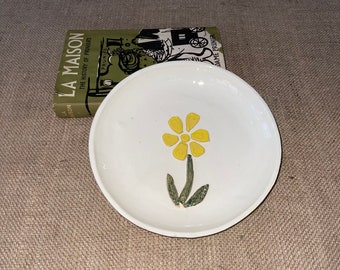 An unusual Handmade ceramic pottery glazed cream 8.5 inch diameter plate with a yellow flower design