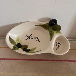 A lovely French hand painted ceramic olive with a place for stones ( Noyaux) an d unusually holes for cocktail picks
