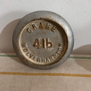 May include: A silver metal weight with the text "CRANE" and "WOLVERHAMPTON" around the edge and the number "416" in the centre.