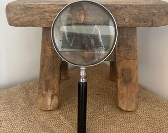 A  vintage black handled, chromed frame Japan stamped magnifying glass