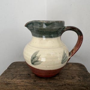 Brocca vintage in terracotta artigianale Wattisfield Ware, nei colori marrone, verde e crema. Reca il marchio SFK (Suffolk) Studio Pottery.