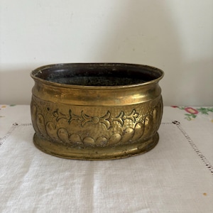 A well used vintage medium size oval shaped French vintage indoor brass planter pot or urn