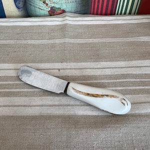 A cute French vintage butter cutter with a china white and gold handle