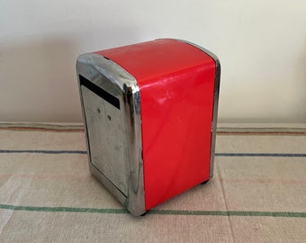 A fun chromed red metal  paper napkin dispenser with sprung metal plates to keep napkins in place
