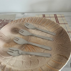 A set of four stainless steel  oyster forks to replicate the restaurant experience