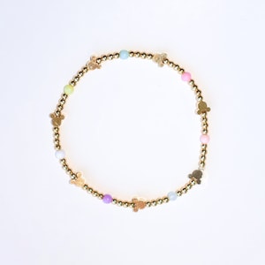 May include: A gold bracelet with pastel colored beads and gold Mickey Mouse charms.