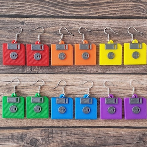 Peut inclure: Un ensemble de 10 paires de boucles d'oreilles avec un motif de disquette. Les boucles d'oreilles sont en plastique et sont disponibles dans une variété de couleurs, notamment le rouge, le bleu, le vert, le jaune et le violet.