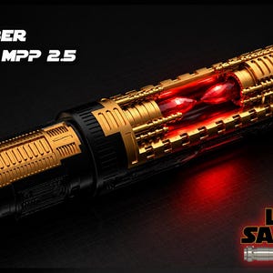 May include: A detailed image of a lightsaber with gold and black accents. The lightsaber has a complex design with visible internal components and a glowing red core. The text "89 SABER VADER MPP 2.5" is displayed at the top.