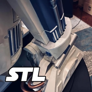 Könnte beinhalten: Nahaufnahme eines weißen und marineblauen Modells mit metallischen Akzenten. Das Modell weist ein komplexes Design mit sichtbaren mechanischen Komponenten auf. Die weißen Buchstaben "STL" sind deutlich zu sehen. Kupferfarbene Rohre setzen einen Kontrast.