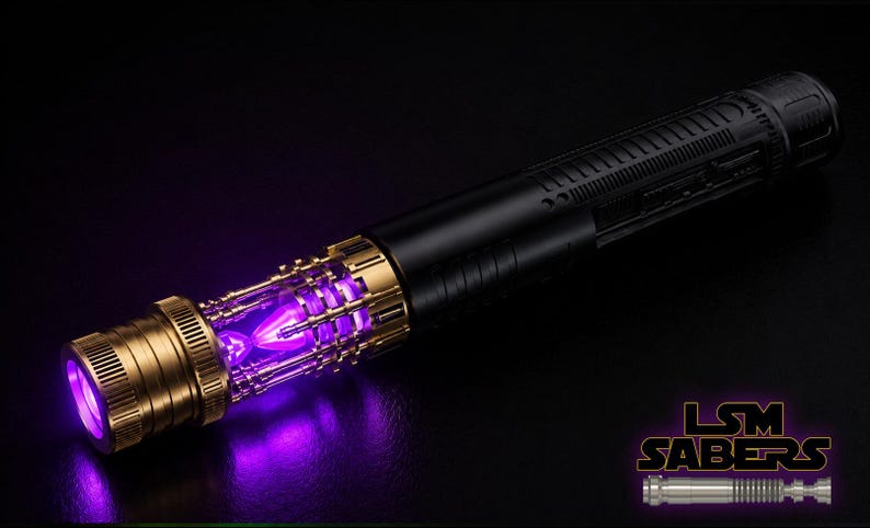 Peut inclure: Un sabre laser noir et dor&eacute; avec une lame violette lumineuse. La poign&eacute;e pr&eacute;sente des d&eacute;tails dor&eacute;s et un corps noir. Cet objet de collection est probablement destin&eacute; au cosplay ou &agrave; l'exposition.
