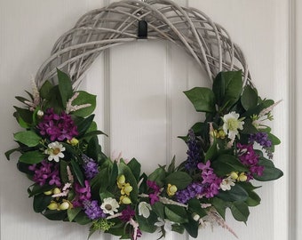 Artificial wildflower country garden wreath for indoor or outdoor use. Bright artificial silk flowers on a grey willow wreath base.