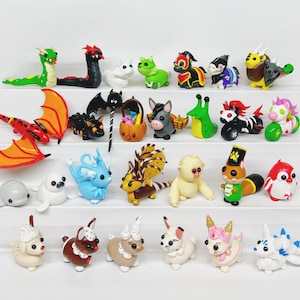 May include: A collection of 24 handmade polymer clay figurines, featuring a variety of animals, creatures, and characters. The figurines are brightly colored and detailed, with a whimsical and playful style.