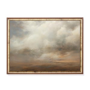 May include: A framed landscape painting featuring a vast, cloudy sky in shades of white, grey, and soft brown above a dark, muted horizon. The artwork is enclosed in a rectangular wooden frame with a thin, distressed gold-toned inner border.